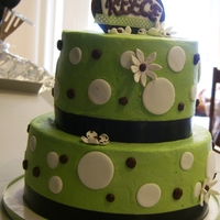 Polka Dots And Flowers Buttercream cake with fondant and gumpaste decorations and some buttercream polka dots. Gumpaste/fabric ribbon topper. Satin ribbon borders...