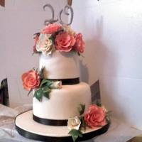 Peach And Ivory Roses gumpaste Peach and Ivory roses with chocolate satin ribbon. 4" and 6" inch yellow cake with chocolate mousse filling.