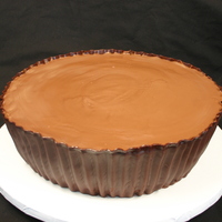 Reese's Peanut Butter Cup Chocolate cake with peanut butter filling containing crushed pb cups, then iced in chocolate buttercream. The paper wrapper is modeling...