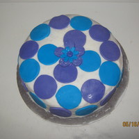 Blue And Purple Pound cake with buttercream icing and blue and purple fondant circles, and a blue and purple fondant flower in the middle