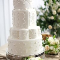 White On White Fondant covered, gumpaste flowers, royal icing piped dots/lines, royal monogram on a fondant plate.