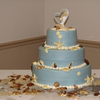 Beach Theme Wedding Cake Buttercream covered cake, painted & poured chocolate shells, rootbeer flavored colored seaglass, colored sugar sand.