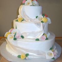 Floral Cake Buttercream 3 tiered cake with fondant drapery and fondant roses, carnations, and calla lillies