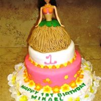 Hula Girl Barbie Cake 3 tier cake. 12 inch bottom, 8 inch middle., and 6 inch around for the hula skirt. All covered in fondant except for the doll had a...