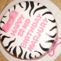 Hot Pink Zebra 9 inch round vanilla cake with dulce de leche filling. Covered in white MMF and decorated with MMF hot pink bows. Also hand painted zebra...