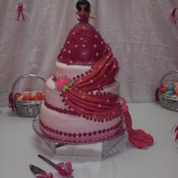 Pricella's Quince Anos Mocha, orange and red velvet cake. Covered with MFF. Additional cake and cupcakes complete the spread.