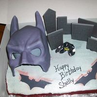 Batman Red Velvet cake covered in Buttercream. Buildings made from fondant, windows royal icing. Mask made from Gumpaste.