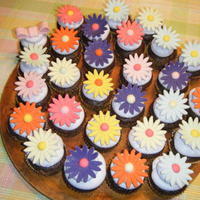 Whimsical Daisies Chocolate WASC with Sugarshacks icing (first time using it-YUM!) Fondant daisies. Made for a bake sale at work for Cystic Fibrosis.