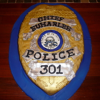 Police Badge Two 9x13 chocolate cakes, torted, filled & iced with vanilla BC. Carved, then covered in homemade MMF and airbrushed. For the detail...