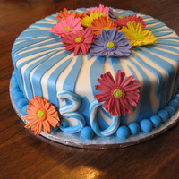 Gerber Daisies Surprise 30th birthday cake. First time making Gerber Daisies, and learned a few things for next time. Cake covered in MMF with daisies...