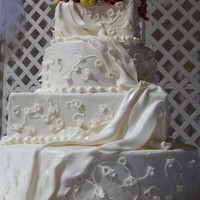 Wedding Drape Flowers are gumpaste. Cake is covered in buttercream. the fabric draped down the front is fonant. the entire cake is airbrushed with super...