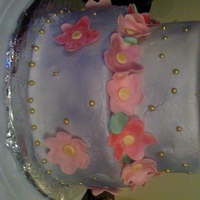 Purple Buttercream Cake With Fondant Flowers Simple buttercream cake airbrushed with purple shimmer. Fondant flowers that were shimmer dusted.