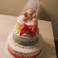 Baby Shower Cake three tier baby shower cake decorated in butterecream and ribbon accents. Small pink monkey topper is made of fondant. This cake was made...