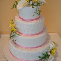 4 Tier Wedding Cake Sugar freesias, jasmine and calla lilies. The side pattern was made using the nouveau tulip patchwork cutter.