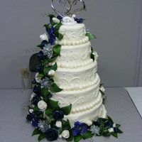 Silver, Navy, Green, And White Wedding Cake This is a stacked 5 tier cake made of white cake and buttercream frosting. The flowers and leaves are all hand made out of fondant as is...