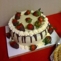 Strawberry Cake Chocolate cake with ganache filling. Topped with creamcheese icing. Strawberries dipped in chocolate to decorate.
