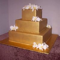 Gold With Orchids Fondant sprayed with gold and white gumpaste orchids with canary throats.
