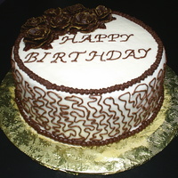 Uncle's Birthday Cake Chocolate cake with vanilla buttercream base. The cornelli lace and roses are raspberry chocolate buttercream. I used gold luster dust to...