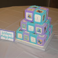Stacked Baby Blocks 3 tier cake iced in buttercream. Edible images coordinated with the invitations.