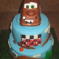 Mater Desert Cake MMF covered cake... RKT Mater covered in MMF and gumpaste decorations. Gumpaste for the road signs and I hand-painted them with food...