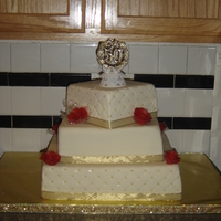 50Th Wedding Anniversary covered in white chocolate mmf, edible gold pearls and hand made chocolate clay roses. Top and bottom tier is white cake with chuncky...