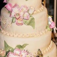 Moms Wedding Cake Four tiered ivory fondant cake with hand-painted gumpaste orchids and flowers. Pink pearls as accent.