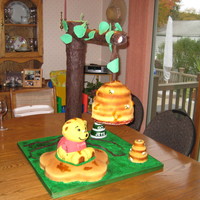 Beehive/winnie The Pooh Cake I made this cake for my cousin's 1st birthday. The beehive, winnie and honeycomb are all made out of cake covered in fondant. The tree...