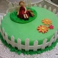 Cake.jpg cake is covered in MMF. girl is made out of GP and fence is made out of half fondant and GP. BC grass border and GP daisies