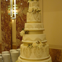 Art Deco Ivory And Gold Wedding Six tier ivory buttercream 24KT gold designs. Fresh flowers.