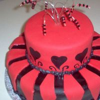 Black & Red Birthday Two Tiered, black and red chocolate cake. Covered with fondant, iced with buttercream. Beaded Wire cake topper. Hand painted accents on 2nd...