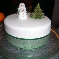 Snowman Cake 8" Madeira Sponge cake, iced with buttercream, filled with custard, and covered with fondant. Hand sculpted fondant Trees and Snowmen...