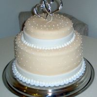 White & Ivory Chocolate Ganache Two Tiered, 10" and 6" devil's food chocolate. Filled and iced with whipped chocolate ganache, covered in ivory fondant and...