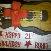 Guitar Cake Chocolate cake, chocolate icing, fondant guitar and bow. Used 2 layers of the Wilton's guitar pan.