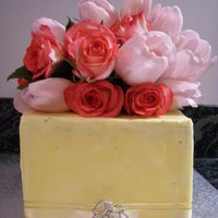 Rose And Tulip Cake Two tier choc mud and caramel mud layered with buttercream and coated with buttercream and decorated with fresh flowers.