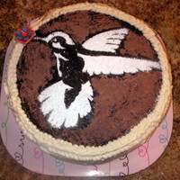 Hummingbird Cake Hummingbird stenciled with cocoa powder and powded sugar, Chocolate cake, fresh bananas inside with banana buttercream.