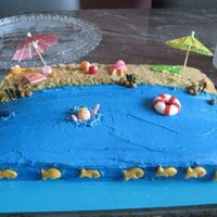 Beach Cake Cake made for an end of the summer party. Cake is chocolate and covered in BC. Decorations are made from MMF. Fishies are goldfish crackers...