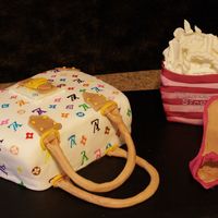 Purse Cake With Shopping Bag And Shoe The purse cake is covered in fondant and the Louis V insignia was handpainted on. The purse bag's handles and accents were done in...