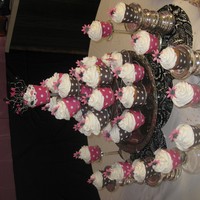 029_1254794574.jpg Cupcake sculpture I made for ladies tea....Chocolate cupcakes vanilla Buttercream with pink and black gumpaste daisies!
