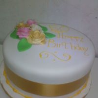 Golden Birthday Fondant covered butter cake with hand moulded fondant roses and fondant leaves.