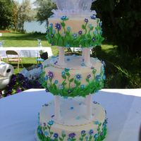 Gavin Cake This cake was covered in buttercream and had blue and puple fondant flowers of different size in the cake with green leaves at the bottom...