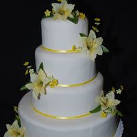 Spring Wedding This is a fondant covered cake with yellow lilies and misc flowers.