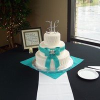 Quilted Quilted 6, 10, and 14" round with silver dragees. Gumpaste bow and edible brooch.