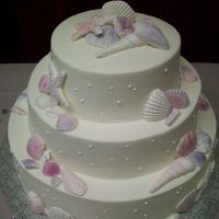 Seashell Cake Three tier cake, iced in buttercream, decorated with sugar shells dusted with lustre dust.