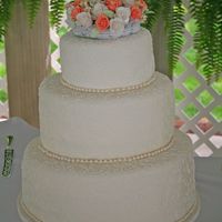 Scrollwork Round Wedding Cake Fondant wedding cake covered in white scrollwork, gumpaste flowers.