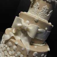 Vintage Buttercream with fondant bow and vintage buttons and lace appliques.Gumpaste flowers for topper