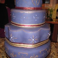 Purple And Gold Celebration fondant covered cake, with gold and purple piping (the purple looks white because ofthe flash). ribbon details, and a gold carnation as a...