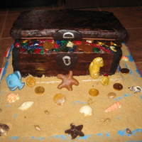 Treasure Of The Black Pearl Treasure chest scene for pirate-themed 30th birthday.Vanilla, oreo, and vanilla cake layers, covered in chocolate fondant. RKT for lid....