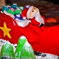 Santa Clause this is my first fondant figure, i made a big 16X16base, and i carved the sleigh out of cake as well, all accents are fondant and i covered...