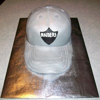 Raiders Hat Oakland Raiders ball cap. Mocha cake and mocha ganache filling. Covered in MMF with luster dust.