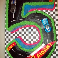 5Th Birthday Hot Wheels #5 cut out of sheet cake, iced in buttercream with fondant accents. Toy hot wheel cars